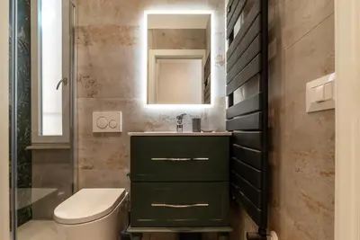 a bathroom with a green vanity and a mirror at GuestHost - Rome Huge & Cozy Apartment in Rome
