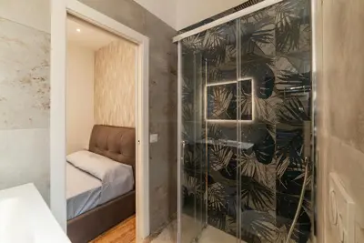 a room with a glass shower with a bed at GuestHost - Rome Huge & Cozy Apartment in Rome