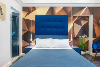 a bedroom with a blue bed and a colorful wall at Antiqua Domus in Rome