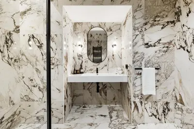 a marble bathroom with a sink and a mirror at Adriana Boutique Guest House in Rome
