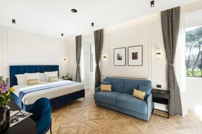 a hotel room with a bed and a blue couch at Adriana Boutique Guest House in Rome