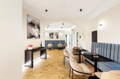 a living room with tables and chairs and a couch at Adriana Boutique Guest House in Rome
