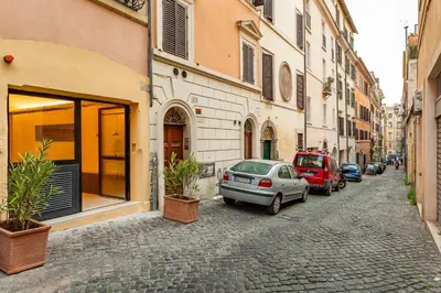 a street with cars parked on a cobblestone street at Officina Daplace in Rome
