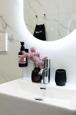 a bathroom sink with flowers and a mirror at Belli Boutique Guest House in Rome
