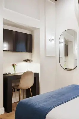 a bedroom with a bed and a desk and a mirror at Sistina Boutique Guest House in Rome