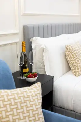 a table with a bottle of champagne and a bowl of fruit at Sistina Boutique Guest House in Rome