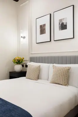 a bedroom with a white bed with two pictures on the wall at Sistina Boutique Guest House in Rome