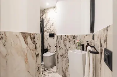 a white bathroom with a toilet and a sink at Sistina Boutique Guest House in Rome