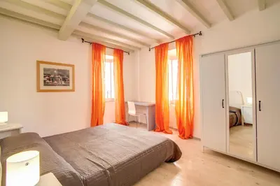 a bedroom with orange curtains and a bed and a mirror at Three Bedroom Apartment Campo dei Fiori in Rome