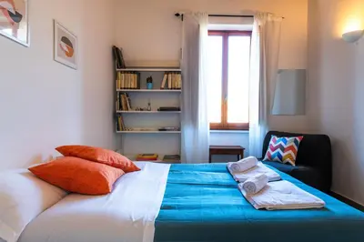 a bedroom with a bed and a chair and a window at Casa Bodoni in Rome
