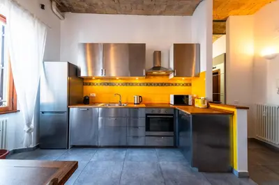 a kitchen with stainless steel appliances and yellow walls at Casa Bodoni in Rome