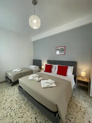 a bedroom with two beds with red pillows at Trastevere Station Sweet Rest in Rome