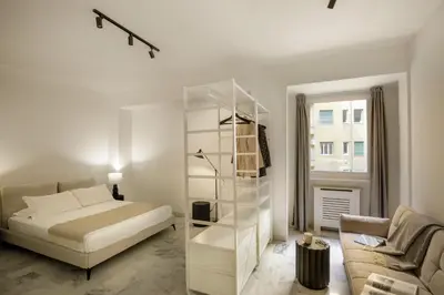 a white bedroom with a bed and a couch at The Right Place 4U Piemonte Apartment in Rome