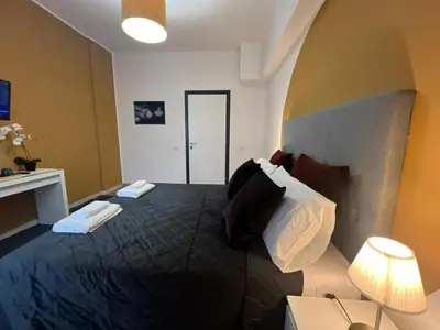 a bedroom with a large black bed with pillows at affittacamere appia nuova 639 in Rome