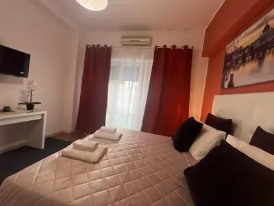 a bedroom with a large bed with red curtains at affittacamere appia nuova 639 in Rome