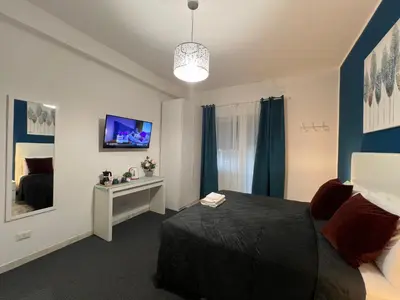 a bedroom with a black bed and a tv at affittacamere appia nuova 639 in Rome