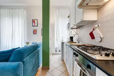 a kitchen with a blue couch and a stove top oven at Apartment Atelier Testaccio in Rome