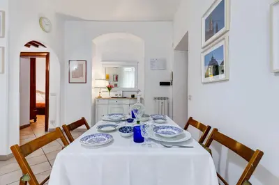 a dining room table with a white table cloth and chairs at Apartment Atelier Testaccio in Rome