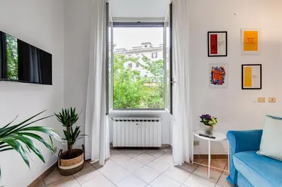 a living room with a blue couch and a window at Apartment Atelier Testaccio in Rome