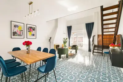 a dining room with a table and blue chairs at Olimpia Boutique Apartment in Rome