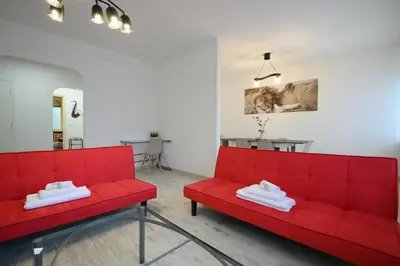 a red couch in a living room with a table at Ponte Milvio Apartment Flaminio in Rome