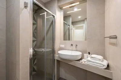 a bathroom with a sink and a glass shower at SJR Luxury Apartment Trevi Fountain in Rome