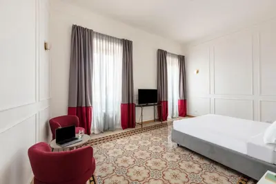 a hotel room with a bed and two chairs at SJR Luxury Apartment Trevi Fountain in Rome