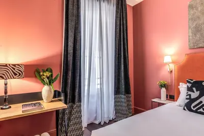 a hotel room with a bed and a window at Telier Belsiana in Rome