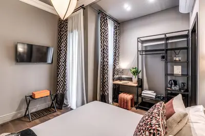 a bedroom with a bed and a tv on a wall at Telier Belsiana in Rome