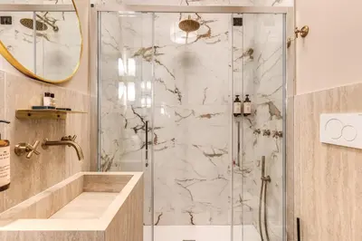 a bathroom with a shower with a glass door at Telier Belsiana in Rome