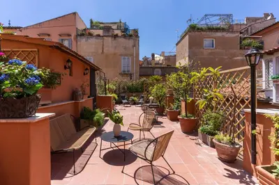 a patio with chairs and tables and potted plants at Telier Belsiana in Rome