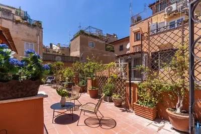 a patio with chairs and potted plants and buildings at Telier Belsiana in Rome