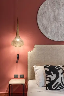 a bedroom with red walls and a bed and a lamp at Telier Belsiana in Rome