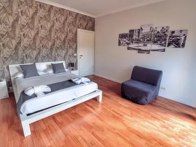 a bedroom with a bed and a blue chair at Vinyle Apartment Vatican in Rome