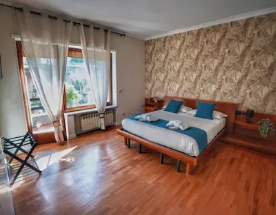 a bedroom with a bed and a large window at Vinyle Apartment Vatican in Rome