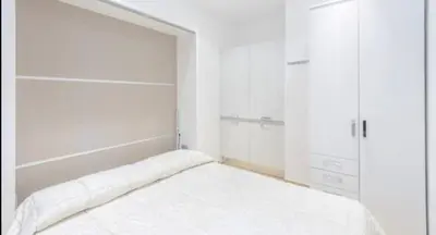 a white bedroom with a bed and two closets at Vinyle Apartment Vatican in Rome