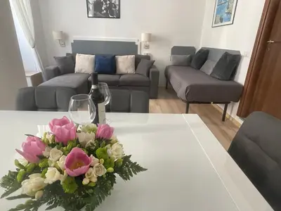 a living room with a table with a vase of flowers at Colosseo studios in Rome
