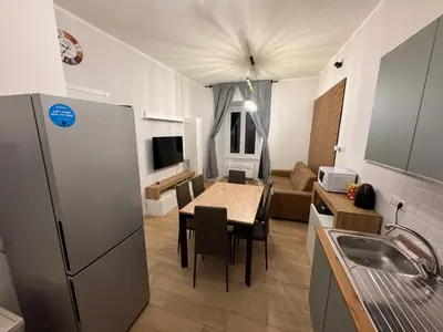 a kitchen and living room with a table and a refrigerator at Angolo Vaticano - Vatican corner in Rome