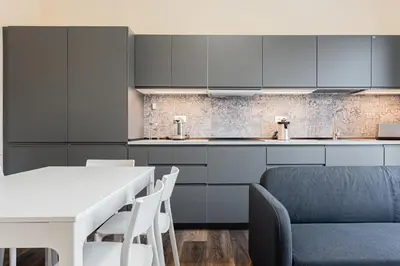 a kitchen with a white table and a blue couch at Prati Grabau Comfort 3 rooms apt in Rome