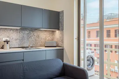 a kitchen with a couch and a sink and a window at Prati Grabau Comfort 3 rooms apt in Rome