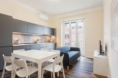a kitchen and living room with a table and a couch at Prati Grabau Comfort 3 rooms apt in Rome