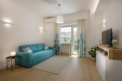 a living room with a blue couch and a tv at Pio Vatican Flat in Rome