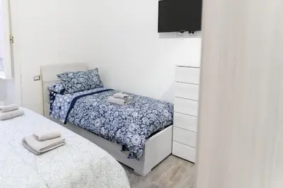 a small bedroom with two beds and a dresser at Central Rome 2BR Walk to Vatican & Piazza Navona in Rome