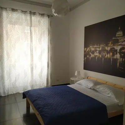 a bedroom with a bed and a large picture on the wall at Morosini House Rome in Rome