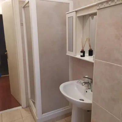 a white bathroom with a sink and a mirror at Morosini House Rome in Rome