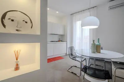 a kitchen and a dining room with a table and chairs at D'Aquino Apartment St. Peter's in Rome