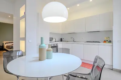 a white kitchen with a white table and chairs at D'Aquino Apartment St. Peter's in Rome