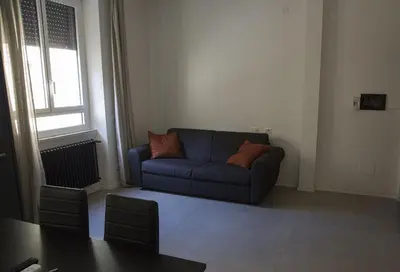 a living room with a blue couch and a table at Appartamento Roman Feelings in Rome