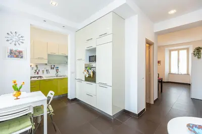 a kitchen with white cabinets and a table at Tasso by Rental in Rome in Rome