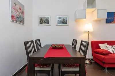 a dining room with a table and a red chair at Tasso by Rental in Rome in Rome